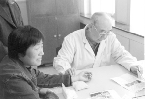 吴咸中（右一）在为患者看病