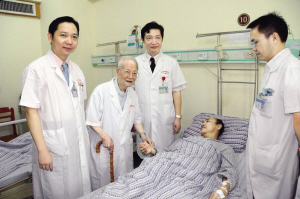 邓铁涛（左二）在给冠脉支架术后患者把脉